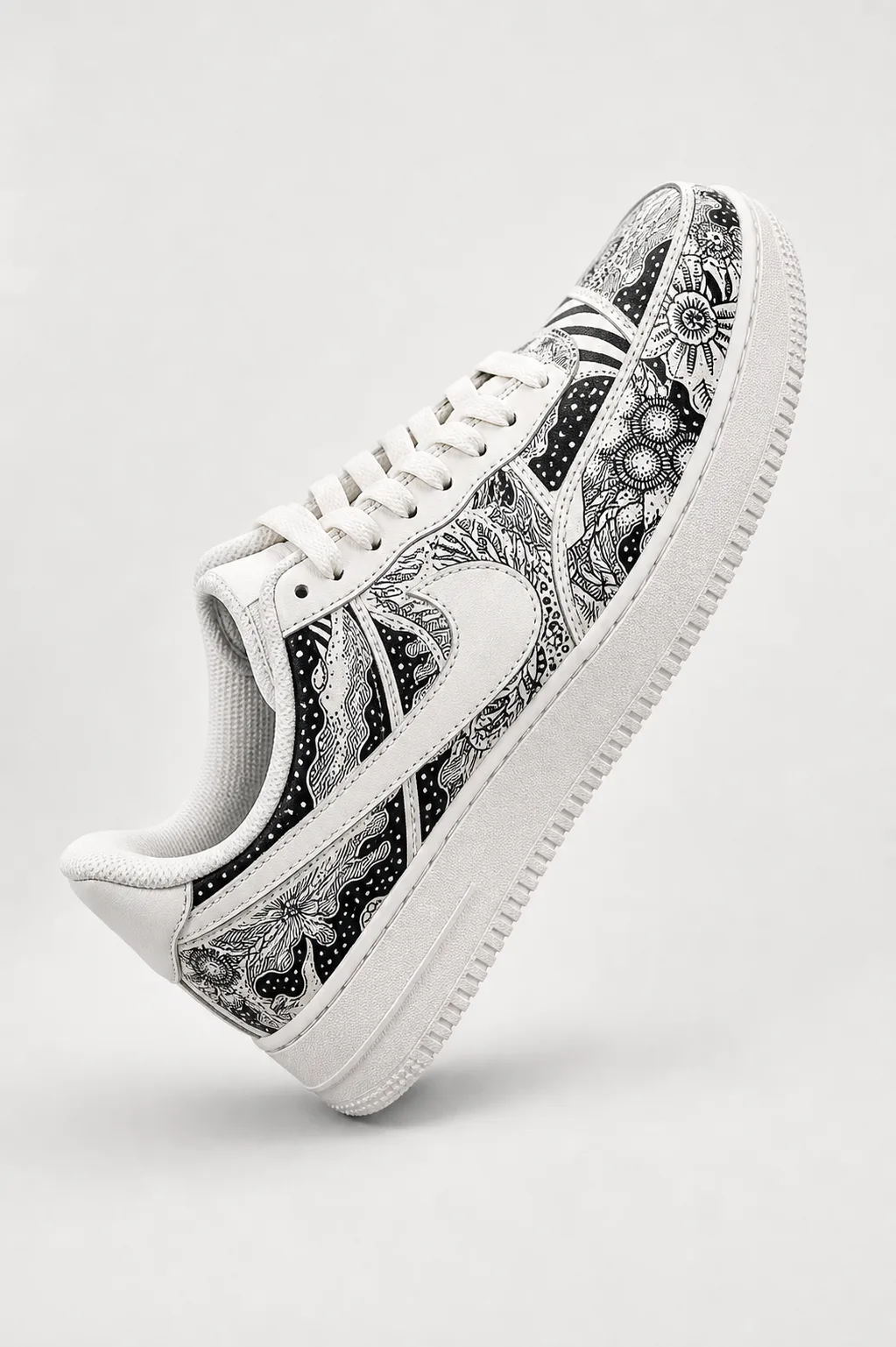 A monochrome hand-painted sneaker photographed clean against a pale studio wall